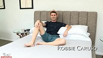 Robbie Caruso puxa as pernas para trás, expondo seu buraco apertado.