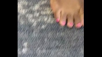 Чернокожая тинка играет ногами с розовыми пальцами ног и подошвами