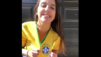 Chica joven muy caliente en pantalones cortos con la camiseta de la selección brasileña
