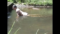 Cumming em uma pedra em um rio