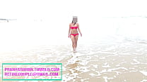 Pranya caminando en la playa en bikini rojo caliente