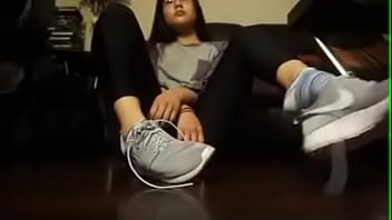 Asian girl takes off her tennis shoes and socks