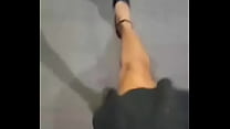 Трансвестит ходит в костюме женщины в высоких кроссовках с красивыми ступнями