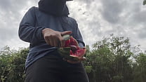 Arbeiter kommt mit Wassermelone.